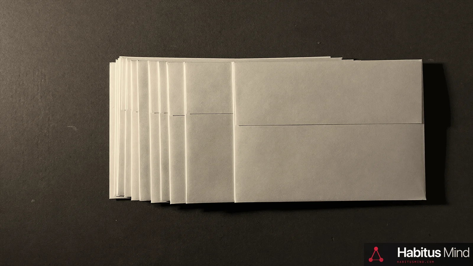A stack of unopened envelopes on a dark surface, one of them slightly separated from the rest